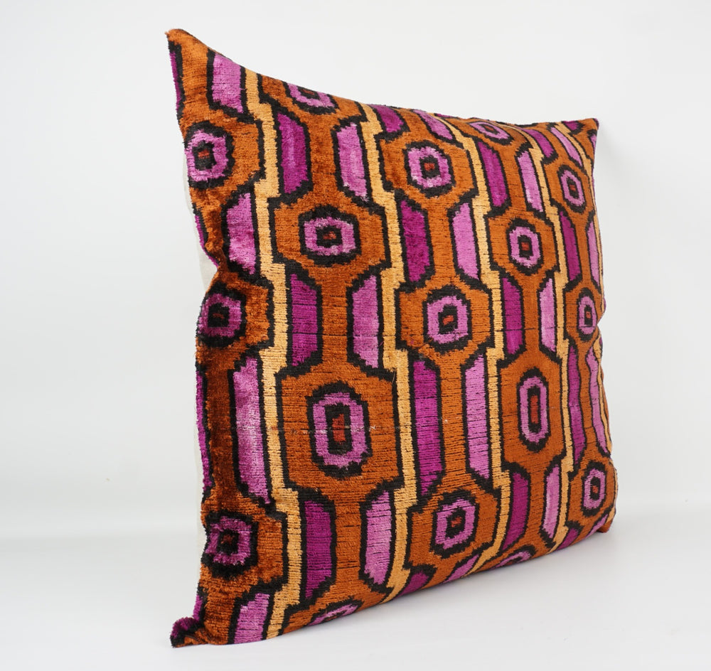 Seidenkissen 50×50cm mit grafischem Retro-Muster in Magenta, Kupfer und Schwarz; Vorderseite 100 % Seide (Silk-Velvet), Rückseite Baumwolle/Leinen.