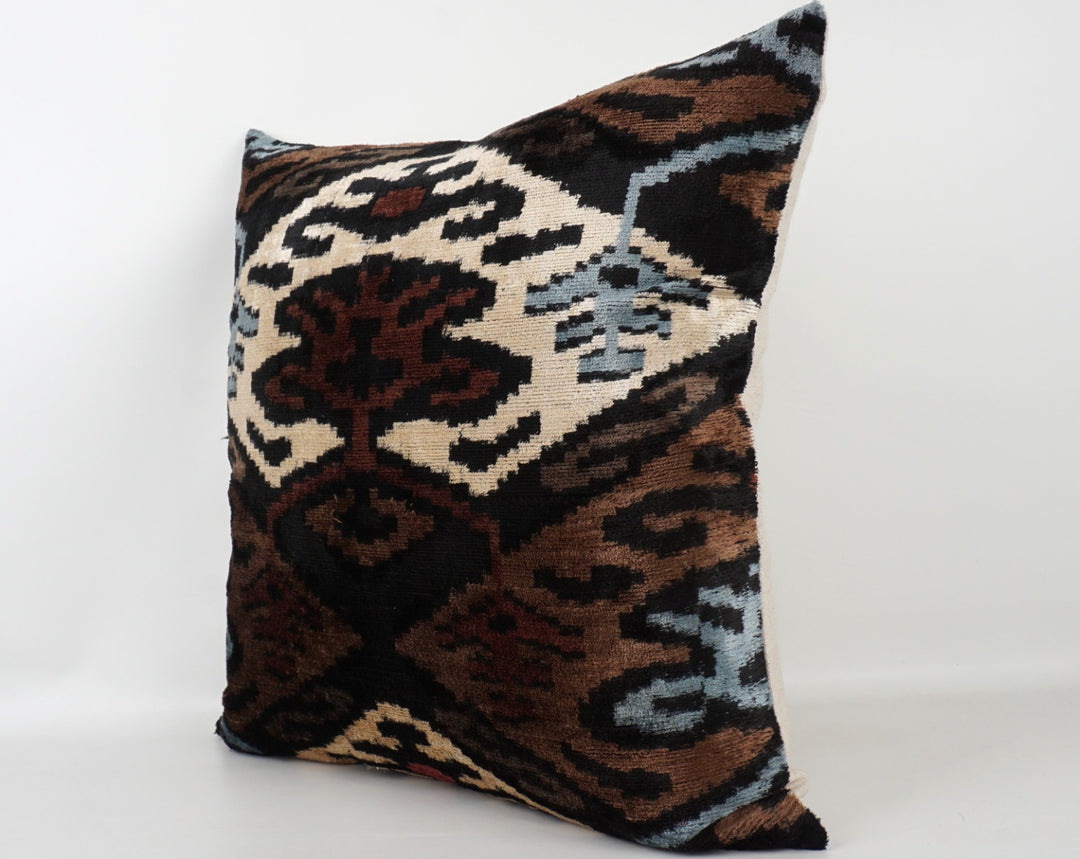 Seidenkissen 50×50 mit Ikat-Muster in Braun, Beere, Blau, Offwhite und Schwarz; Vorderseite 100 % Seide (Silk-Velvet), Rückseite Baumwolle/Leinen.