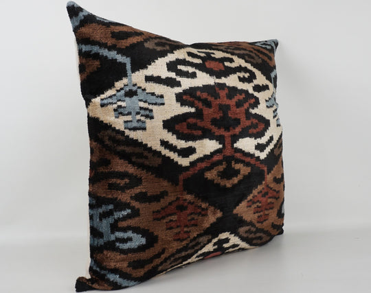 Seidenkissen 50×50 mit Ikat-Muster in Braun, Beere, Blau, Offwhite und Schwarz; Vorderseite 100 % Seide (Silk-Velvet), Rückseite Baumwolle/Leinen.