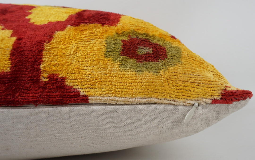 Seidenkissen 50×50 mit Ikat-Blüten in Gelb und Rot; Vorderseite 100 % Seide (Silk-Velvet), Rückseite Baumwolle/Leinen.