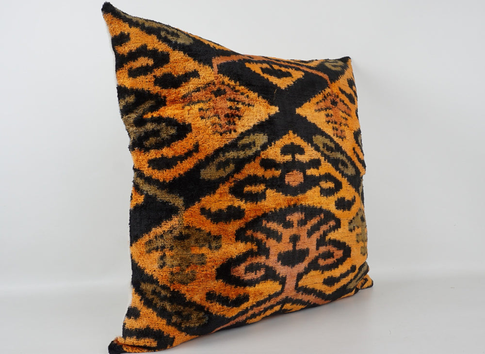 Seidenkissen 50×50 mit Ikat-Muster in Gelb, Orange, Grün und Schwarz; Vorderseite 100 % Seide (Silk-Velvet), Rückseite Baumwolle/Leinen.