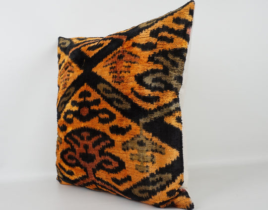 Seidenkissen 50×50 mit Ikat-Muster in Gelb, Orange, Grün und Schwarz; Vorderseite 100 % Seide (Silk-Velvet), Rückseite Baumwolle/Leinen.