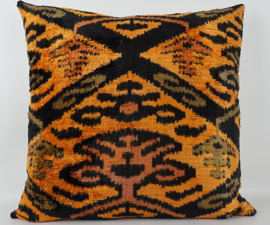 Seidenkissen 50×50 mit Ikat-Muster in Gelb, Orange, Grün und Schwarz; Vorderseite 100 % Seide (Silk-Velvet), Rückseite Baumwolle/Leinen.
