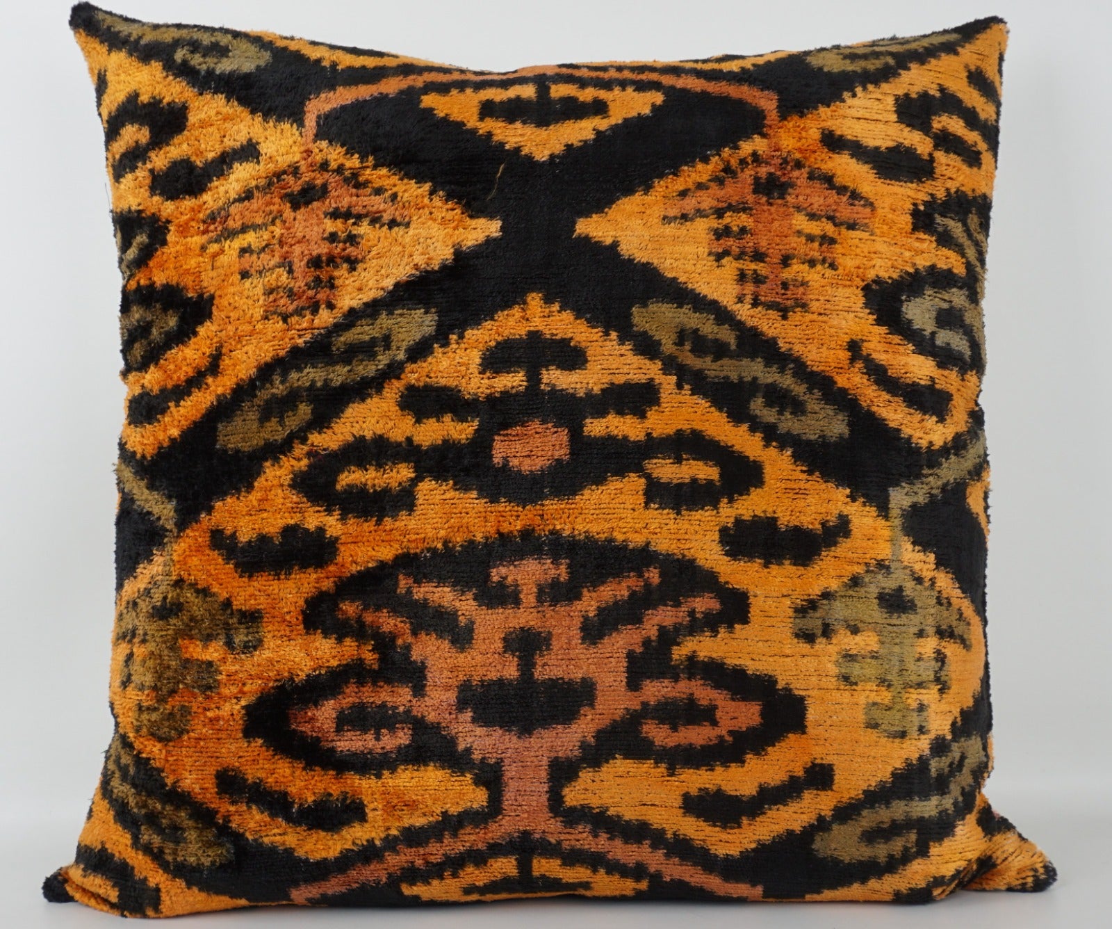 Seidenkissen 50×50 mit Ikat-Muster in Gelb, Orange, Grün und Schwarz; Vorderseite 100 % Seide (Silk-Velvet), Rückseite Baumwolle/Leinen.