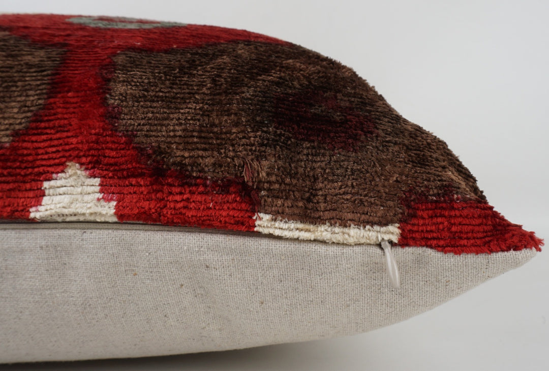 Seidenkissen 50×50 mit Ikat-Rosetten in Rot und Offwhite, Akzenten in Nougat und Grau; Vorderseite 100 % Seide (Silk-Velvet), Rückseite Baumwolle/Leinen.
