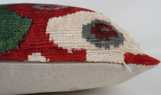 Seidenkissen 50×50 mit Ikat-Rosetten in Rot, Salbeigrün, Offwhite und Grau; Vorderseite 100 % Seide (Silk-Velvet), Rückseite Baumwolle/Leinen.