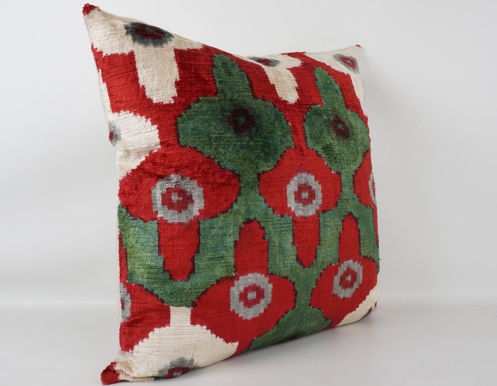 Seidenkissen 50×50 mit Ikat-Rosetten in Rot, Salbeigrün, Offwhite und Grau; Vorderseite 100 % Seide (Silk-Velvet), Rückseite Baumwolle/Leinen.