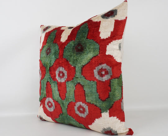 Seidenkissen 50×50 mit Ikat-Rosetten in Rot, Salbeigrün, Offwhite und Grau; Vorderseite 100 % Seide (Silk-Velvet), Rückseite Baumwolle/Leinen.