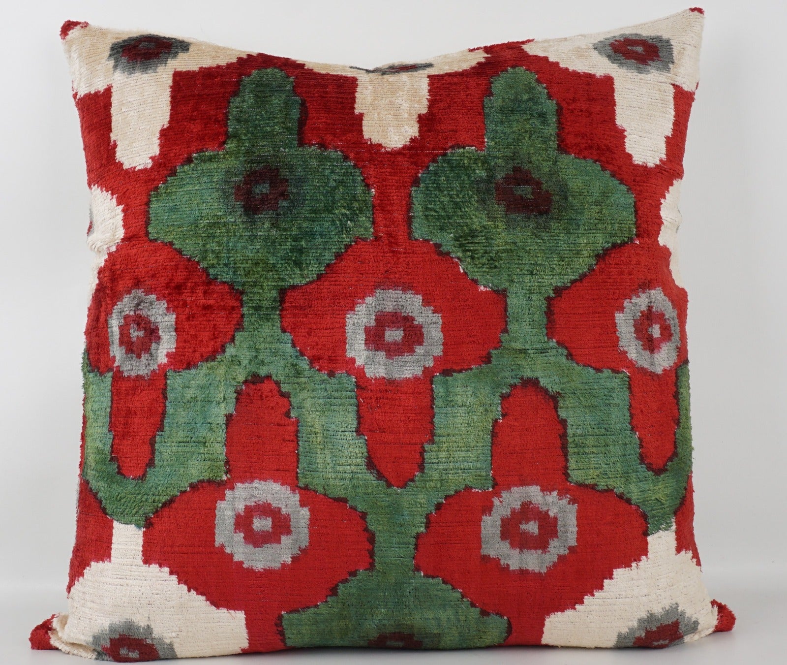 Seidenkissen 50×50 mit Ikat-Rosetten in Rot, Salbeigrün, Offwhite und Grau; Vorderseite 100 % Seide (Silk-Velvet), Rückseite Baumwolle/Leinen.